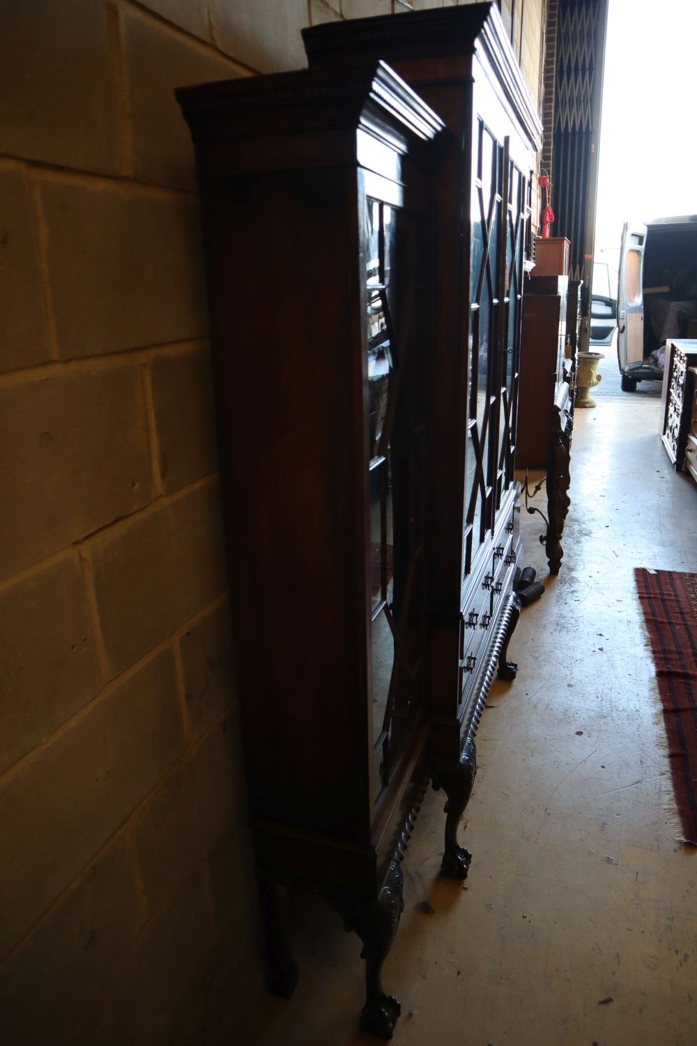 A Chippendale style mahogany breakfront display cabinet fitted four astragal-glazed doors, on cabriole legs with claw and ball feet,